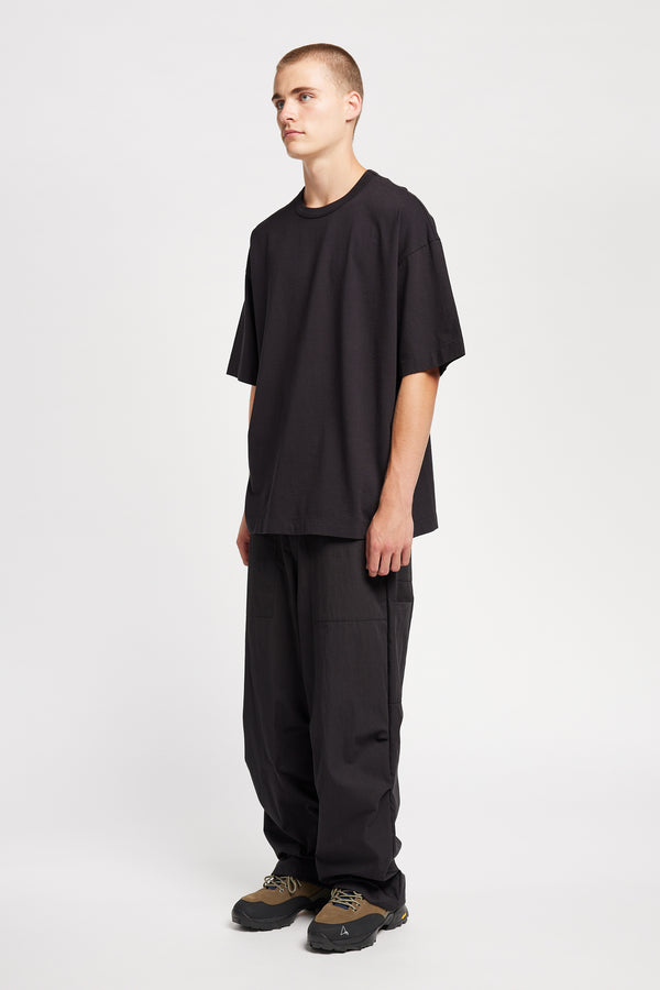 Men - front of model in Monolith Unisex Tee in Black.  Oversized relaxed fit. Available in 6 sizes. Made form 100% Organic Cotton. 