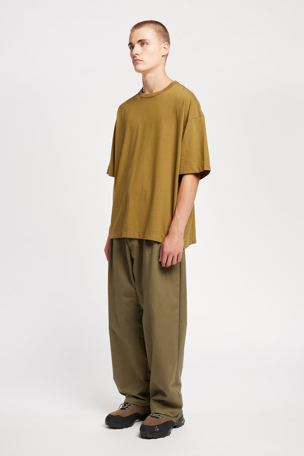 Men - Front of male model in Monolith Unisex Tee in Olive Oil.  Oversized relaxed fit. Available in 6 sizes.