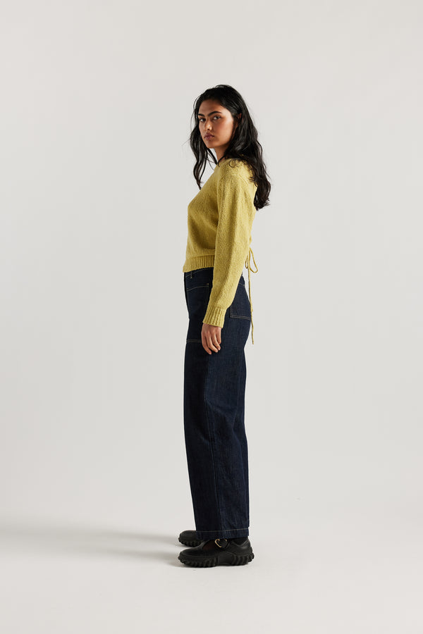 Side of female model in the straight wide-leg denim jeans indigo with a higher-rise waist, patch pockets, and back yoke detail, shown from the front.