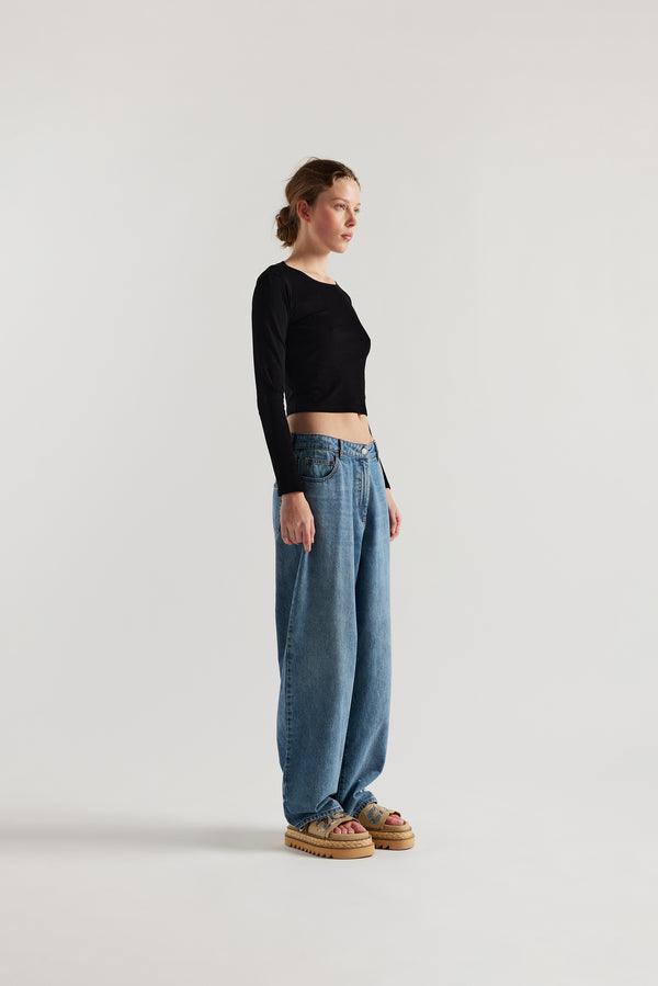 Front angle view of Model wearing Kloke straight-leg jeans in mid-blue Japanese denim, featuring a mid-rise waist and relaxed silhouette