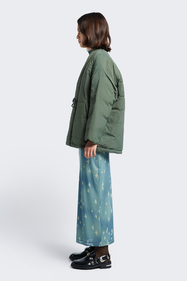 Side view of the Abeyance Quilted Wrap Coat Olive, a Kimono style puffer jacket that can be worn as loose over garment.