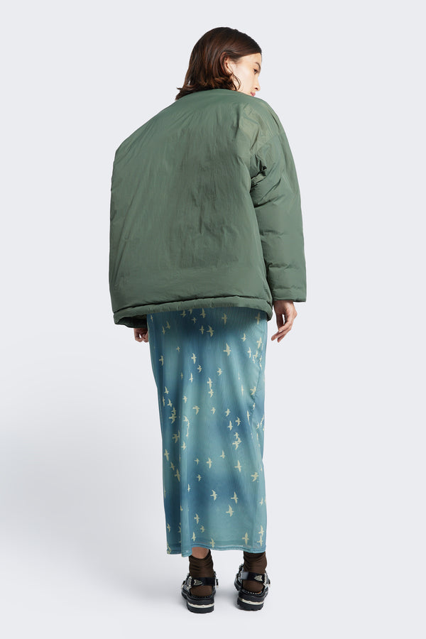 The back of the Abeyance Quilted Wrap Coat Olive, a kimono style puffer jacket made from 100% Recycled Nylon, Lining 100% Recycled Nylon, Fill 100% Post Consumer Down Fill.