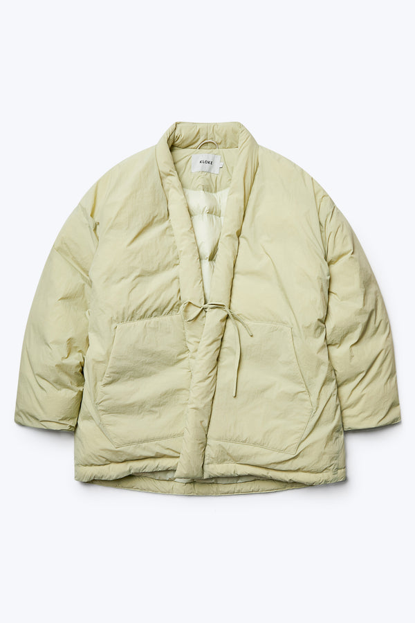 Flat lay of Abeyance Quilted Coat Sand, made from 100% Recycled Nylon, Lining 100% Recycled Nylon, Fill 100% Post Consumer Down Fill