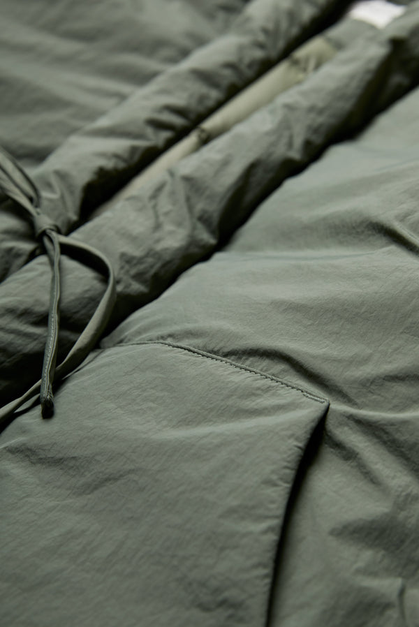 The Abeyance Quilted Wrap Coat Olive  is made 100% Recycled Nylon, Lining 100% Recycled Nylon, Fill 100% Post Consumer Down Fill