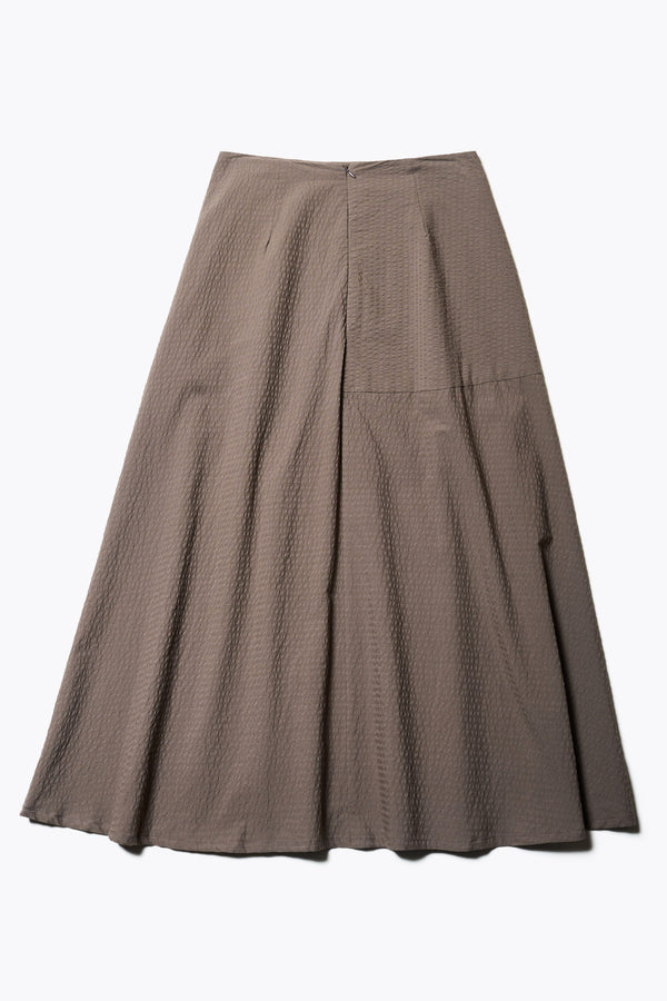 The Back of the Abroad Panel Skirt, fitted at the waist with a bias-cut maxi silhouette, made from 100% cotton in Brown Seersucker. Features panel details, side pockets, and an invisible back zip. Available in 6 sizes