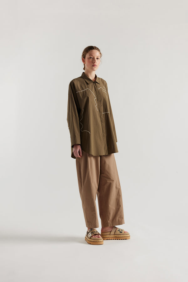 Olive green/brown Ache Embroidered Shirt front view on female model, with embroidered motifs, long sleeves, and built-in collar