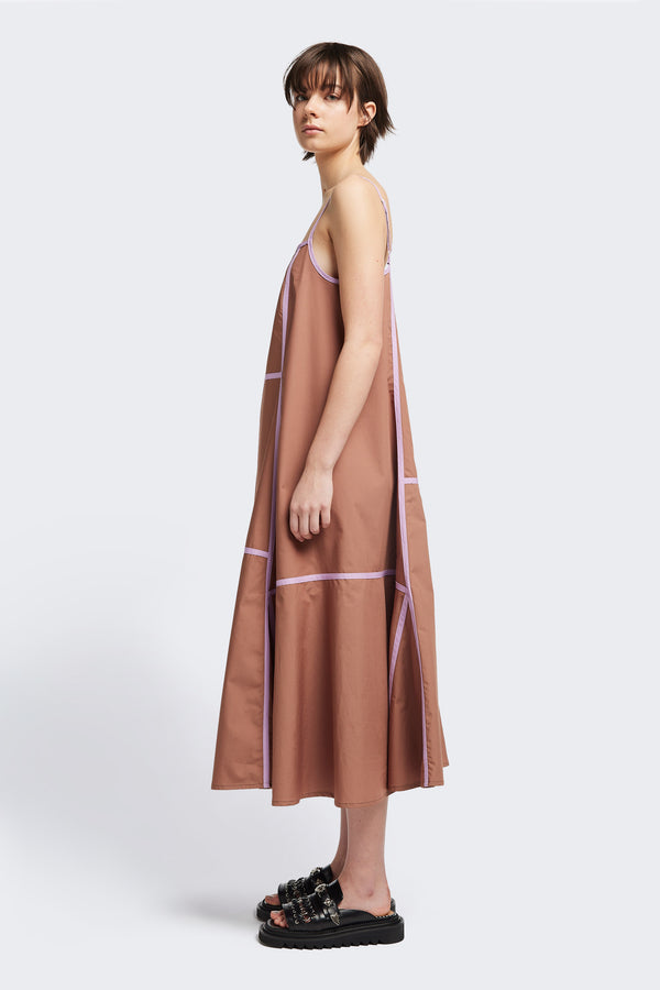 Side of the Adjourn Dress in brown/lilac, featuring contrasting block colours, bound seam details, adjustable thin straps, a straight neckline, and a flared A-line skirt. Available in 5 sizes. 