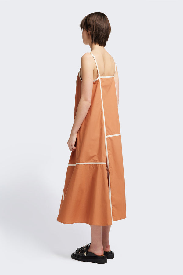 Back of the Adjourn Dress in burnt orange/ecru, featuring contrasting block colours, bound seam details, adjustable thin straps, a straight neckline, and a flared A-line skirt. Available in 5 sizes. 