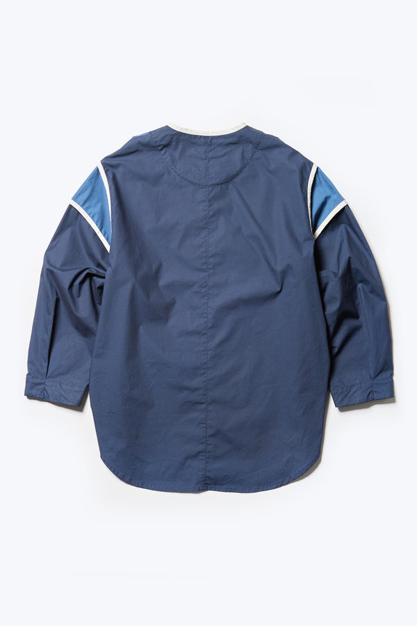 Flat Back of The Ages shirt in blue, a Patchwork-style shirt with block colours, bound seams, rounded neckline, centre front button opening, and rounded hemline, offering a relaxed, modern fit