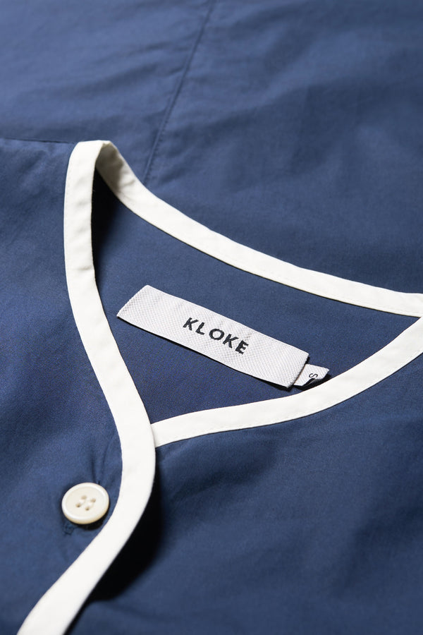 Close up fabric details of The Ages shirt in blue, a Patchwork-style shirt with block colours, bound seams, rounded neckline, centre front button opening, and rounded hemline, offering a relaxed, modern fit