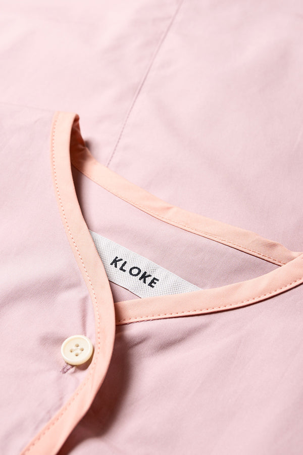 Close up fabric details of The Ages shirt in peach, a Patchwork-style shirt with block colours, bound seams, rounded neckline, centre front button opening, and rounded hemline, offering a relaxed, modern fit