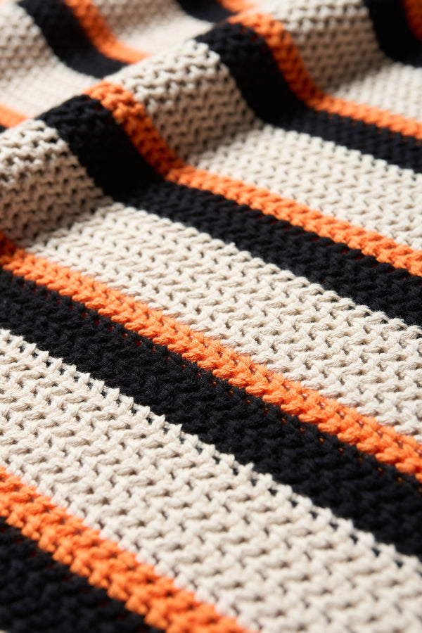 Close up details of the Aperto Crochet Tank in 100% soft cotton, featuring a shallow horizontal stripe in black, orange, and cream. 