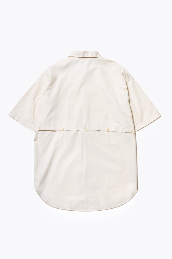 Flat Back of the Aquifer, a relaxed loose-fitting boxy short-sleeve shirt with back button placket, scoop hemline, and chest patch pockets, crafted in lightweight cotton poplin. Available in 5 sizes. 