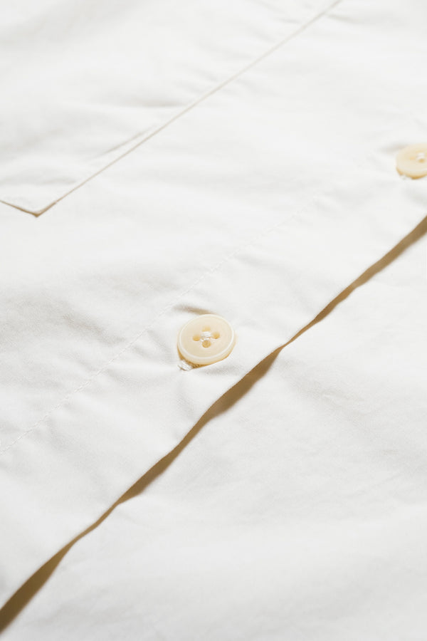 Details of the Aquifer, a relaxed loose-fitting boxy short-sleeve shirt with back button placket, scoop hemline, and chest patch pockets, crafted in lightweight cotton poplin. Available in 5 sizes. 