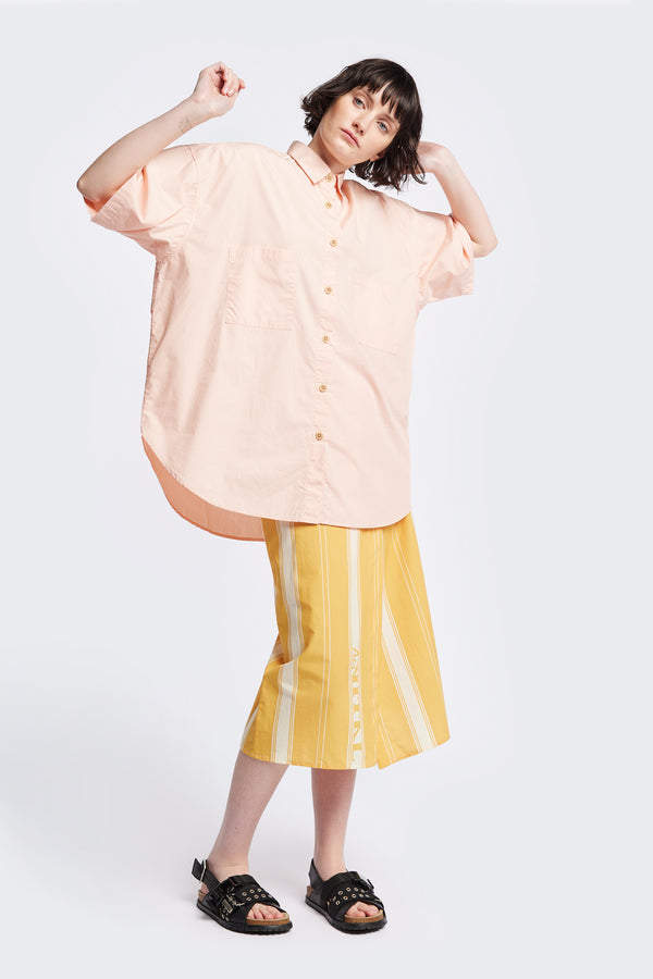 (women) Relaxed loose-fitting boxy short-sleeve shirt with back button placket, scoop hemline, and chest patch pockets, crafted in lightweight cotton poplin. Available in 5 sizes.  