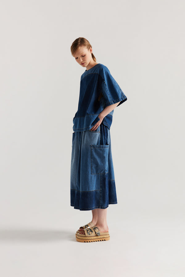Front side view of Dark/Mid Blue Fade Aria Panel Skirt showing panelled denim construction, scoop pockets, and elasticated waistband.