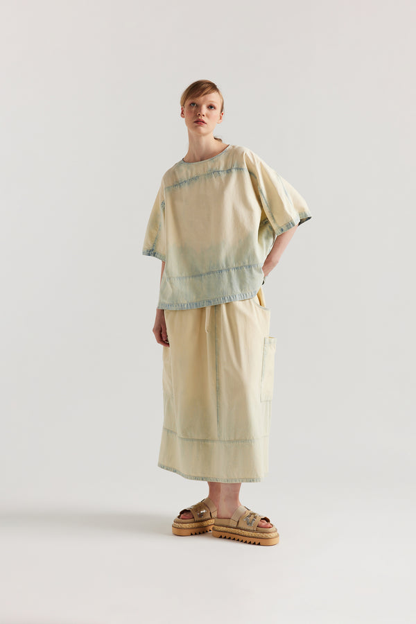 Front view of Mid Blue Fade w Ecru Tint Aria Panel Skirt showing panelled denim construction, scoop pockets, and elasticated waistband.