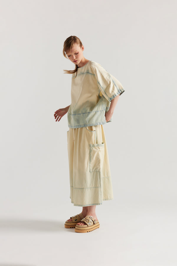 Front view of Mid Blue Fade w Ecru Tint Aria Panel Skirt showing panelled denim construction, scoop pockets, and elasticated waistband.