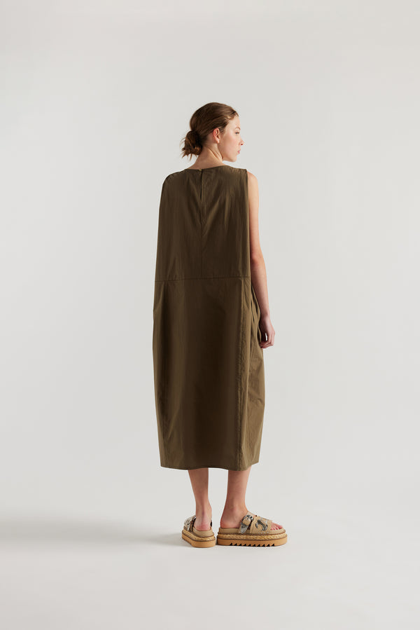 Back view of female model in the olive  Aureole Dress front view showing panelled detailing and relaxed skirt with front inseam split