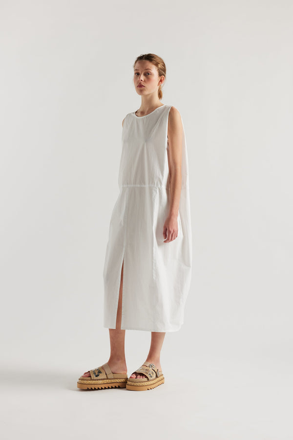 Front view of female model in the white  Aureole Dress front view showing panelled detailing and relaxed skirt with front inseam split