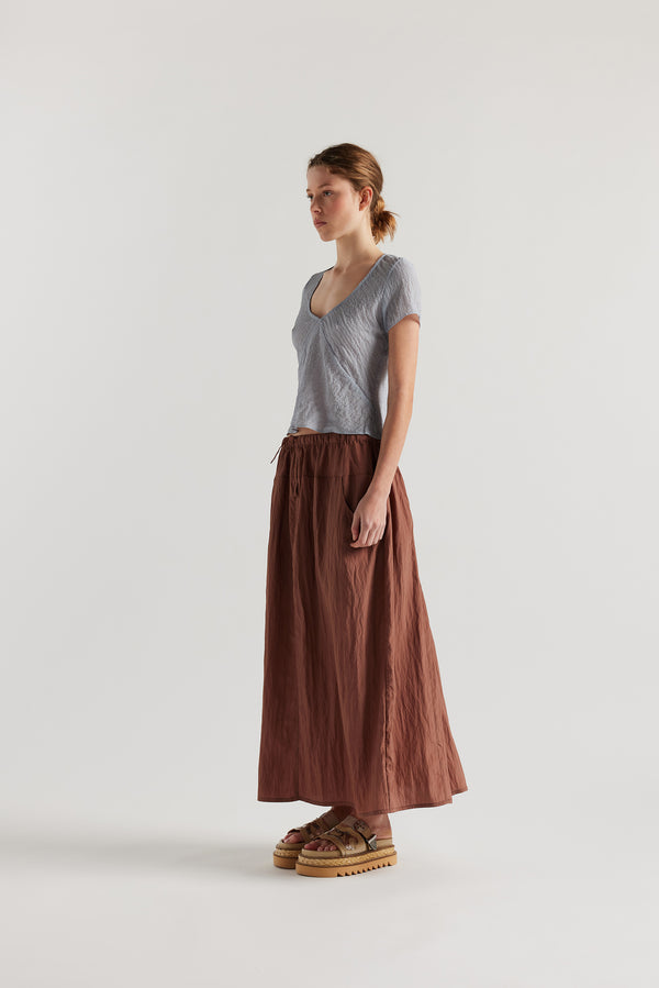 Front view of Model in the Pale Blue Centered top. A Slim-fit V-neck top in sheer textured fabric with cap sleeves and bias cut silhouette.