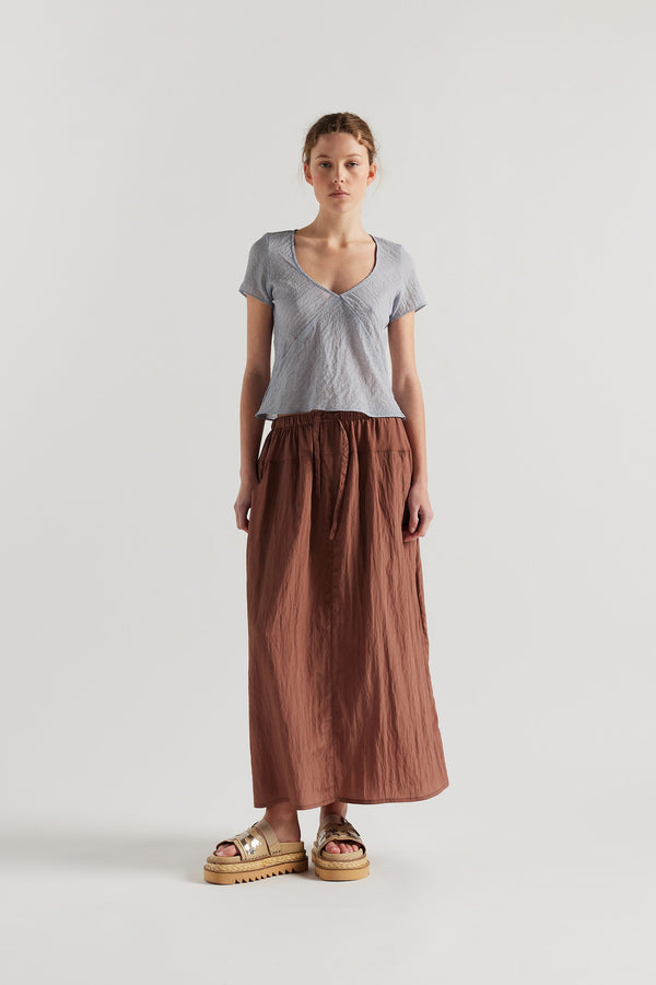 Front view of Model in the Pale Blue Centered top. A Slim-fit V-neck top in sheer textured fabric with cap sleeves and bias cut silhouette.