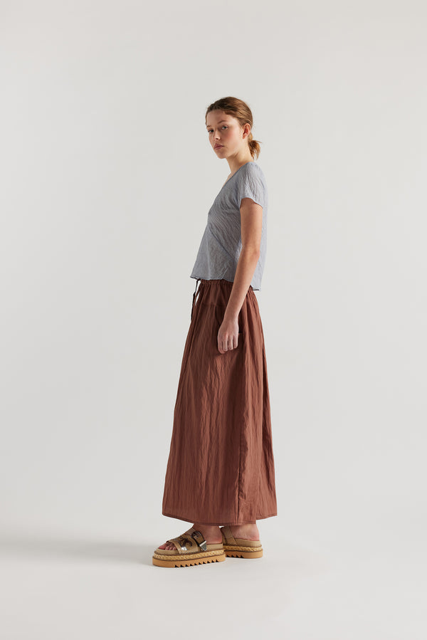 Side view of Model in the Pale Blue Centered top. A Slim-fit V-neck top in sheer textured fabric with cap sleeves and bias cut silhouette.