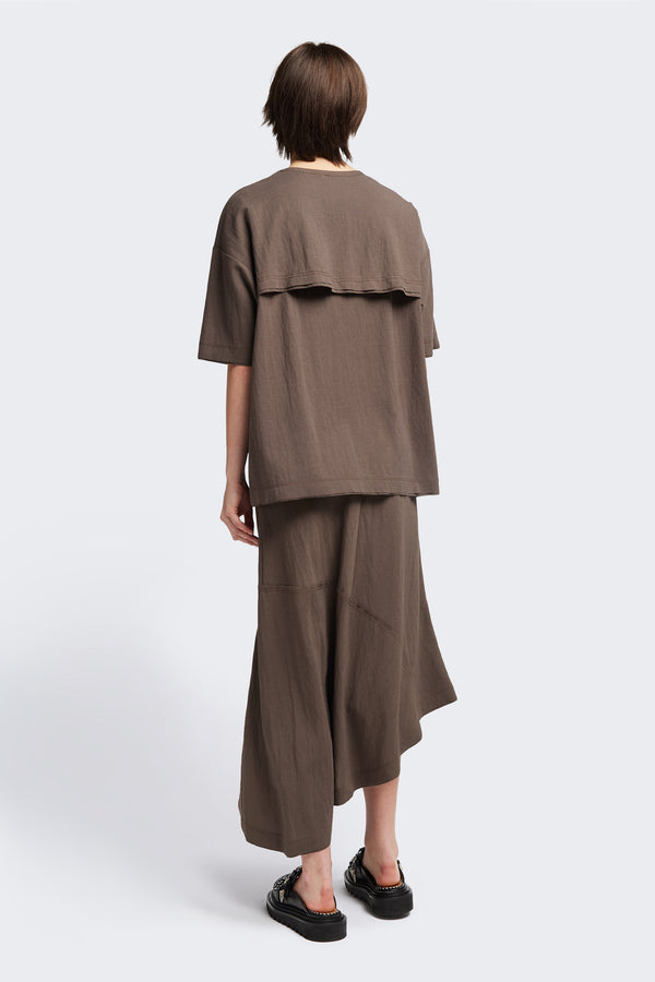 Back of the Chaise top in Taupe, a relaxed crew-neck top in a Japanese rayon blend with short sleeves, boxy fit, raw hemline, and exposed seam detail across the mid-back.