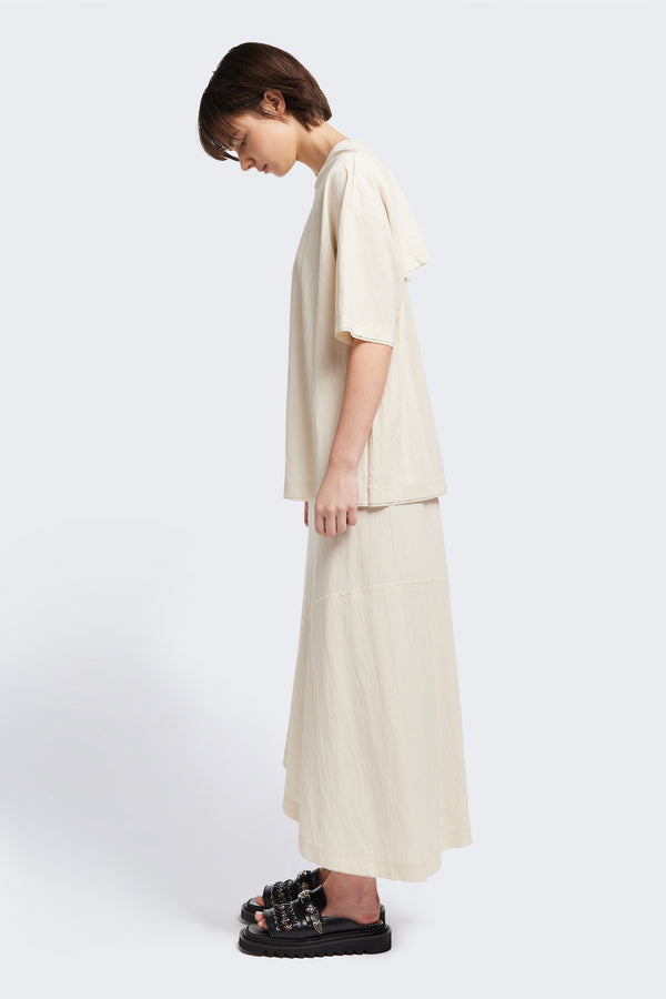 Side of the Chaise top in Ecru, a relaxed crew-neck top in a Japanese rayon blend with short sleeves, boxy fit, raw hemline, and exposed seam detail across the mid-back.