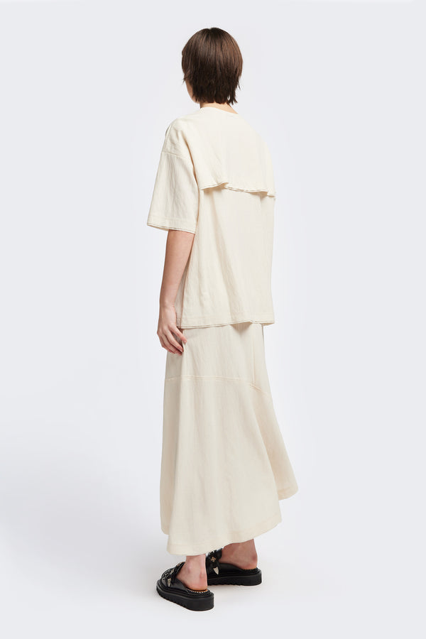 Back of the Chaise top in Ecru, a relaxed crew-neck top in a Japanese rayon blend with short sleeves, boxy fit, raw hemline, and exposed seam detail across the mid-back.