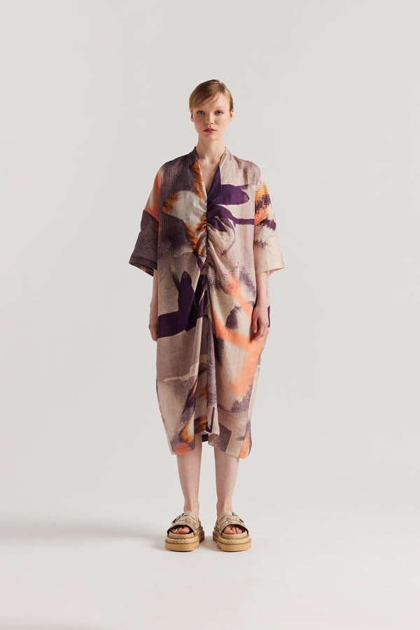 Front angle of model wearing the Chaos dress a relaxed V-neck linen dress in the Kloke Custom Chaos print, gathered at the centre front.  