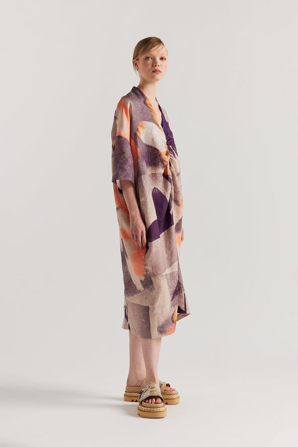 Side angle of model wearing the Chaos dress a relaxed V-neck linen dress in the Kloke Custom Chaos print, gathered at the centre front.  