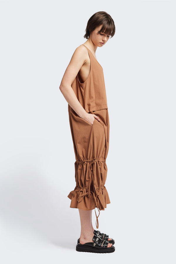 Side view of the cloud dress in toffee brown, a relaxed-fit sleeveless dress with wide shoulder straps, a scoop neckline.