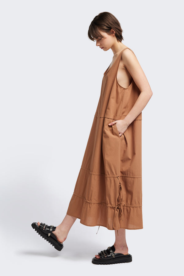 Side view of the cloud dress in toffee brown, a relaxed-fit sleeveless dress with wide shoulder straps, a scoop neckline.