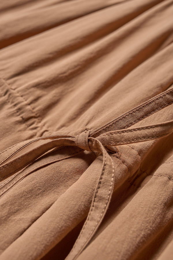 Close up fabric view of the cloud dress in toffee brown, a relaxed-fit sleeveless dress featuring wide shoulder straps and a scoop neckline.