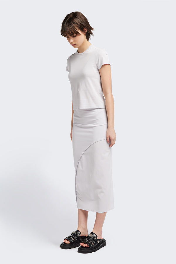 Front view of The Cumulus Skirt in white ice blue. A Slim, mid-calf dress in a cotton blend with stretch, featuring a curved bound seam for a flattering silhouette.