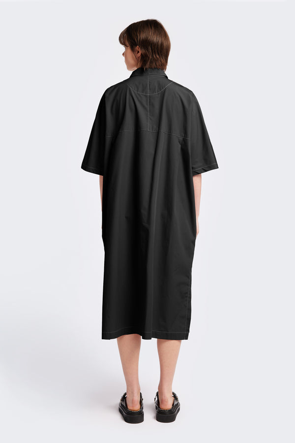 The back of the Daily Dress, a shirt style dress in Black with white contrast topstitch. This dress is an oversized and relaxed style finishing just below the knees. 