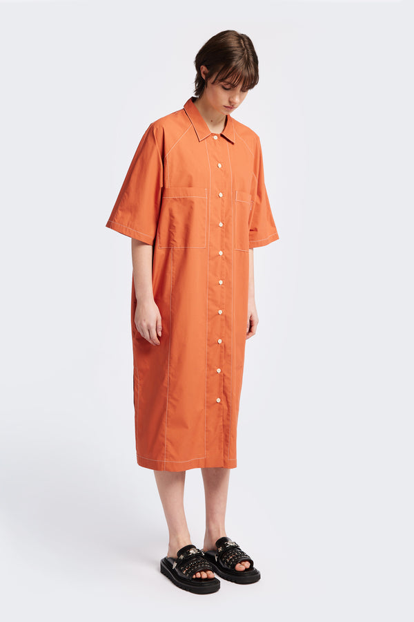 The Daily Shirt Dress is a midi-length, oversized and relaxed style with elbow grazing sleeves. Featuring tall side slits for ease of movement. Made from all natural cotton in Rust with white contrast topstitch.