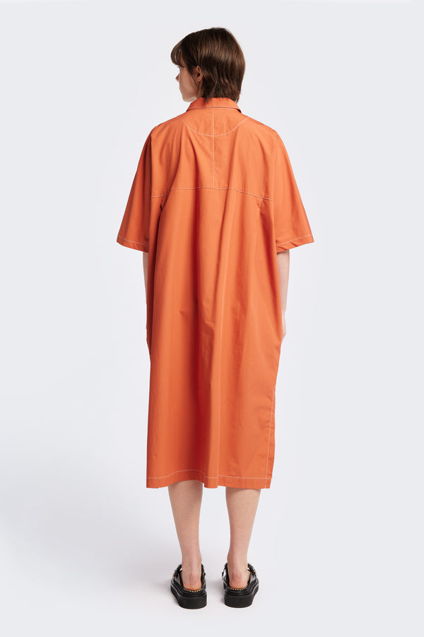 The back of the Daily Dress, a shirt style dress in Rust with white contrast topstitch. This dress is an oversized and relaxed style finishing just below the knees. 