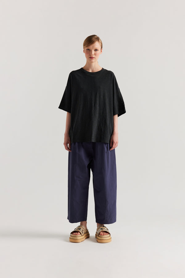 Front view of model in the Jet Balck Declare Tee in pigment-dyed slub cotton with relaxed boxy fit 
