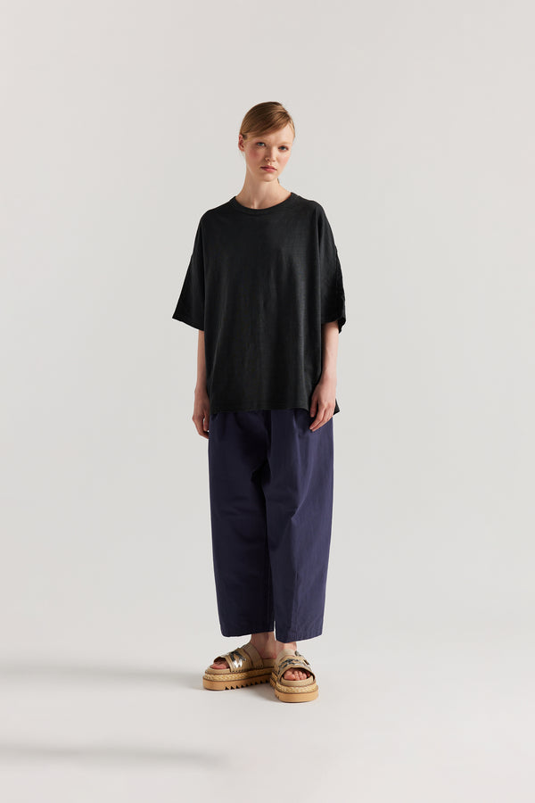 Front view of model in the Jet Balck Declare Tee in pigment-dyed slub cotton with relaxed boxy fit 