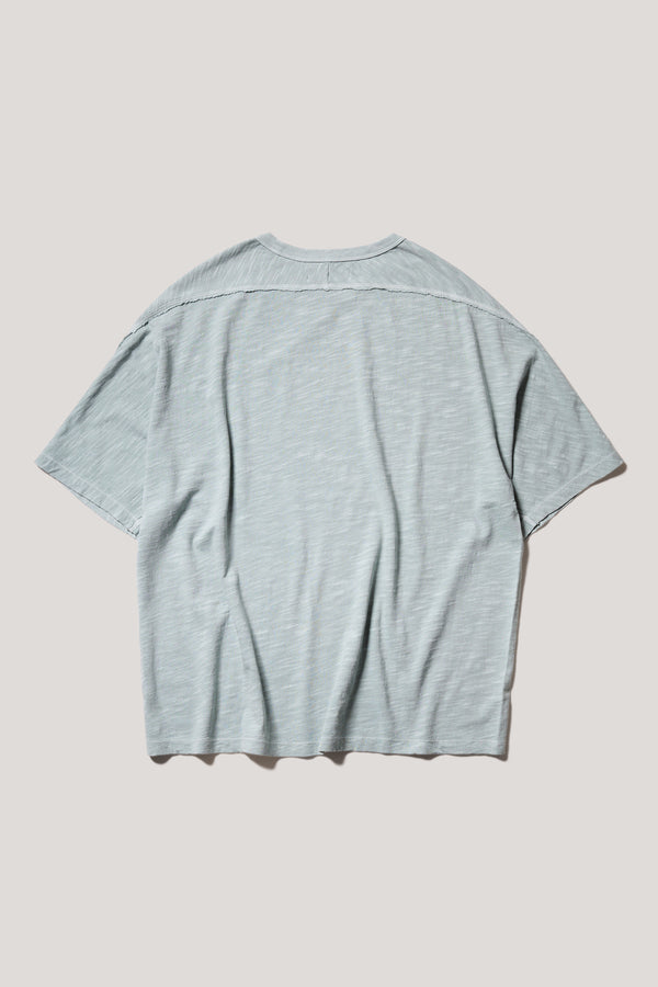 Flat back of the Pale Blue Declare Tee in pigment-dyed slub cotton with relaxed boxy fit - highlighting the overlocked seam detailing. 