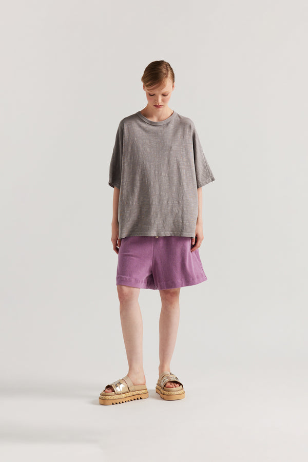 Front view of model in the Mauve Declare Tee in pigment-dyed slub cotton with relaxed boxy fit 