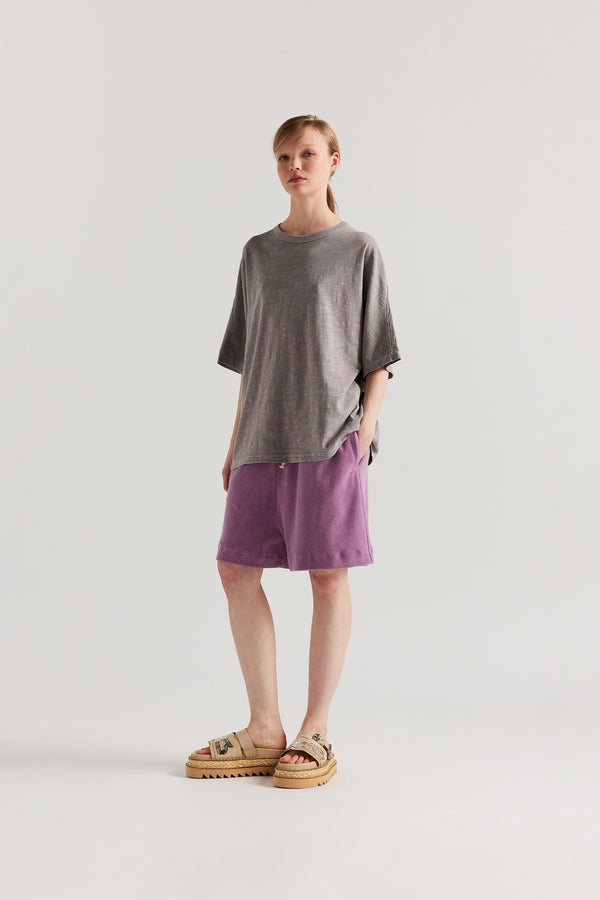 Front view of model in the Mauve Declare Tee in pigment-dyed slub cotton with relaxed boxy fit 