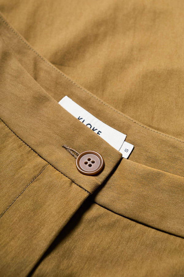 Close up fabric view of Tailored Depth Short in Olive Brown, crafted from soft cotton with pleat front detail, slant pockets, and a relaxed wide leg. Finished with back dart detailing and patch pockets. Available in 6 sizes. 