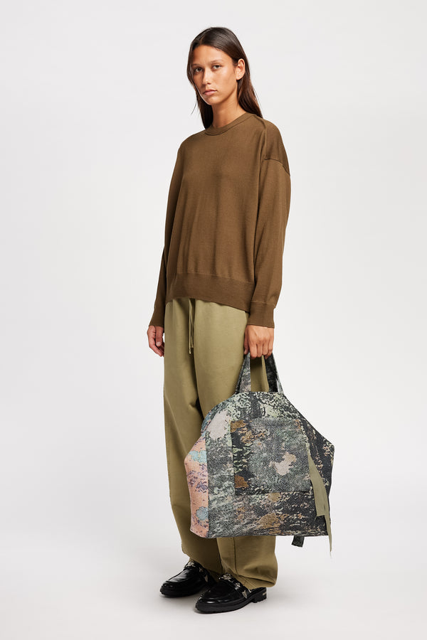 Front angle view on Model of the Descend Loose Fit Merino Knit in brown, a relaxed-fit merino wool sweater with a crew neck. 