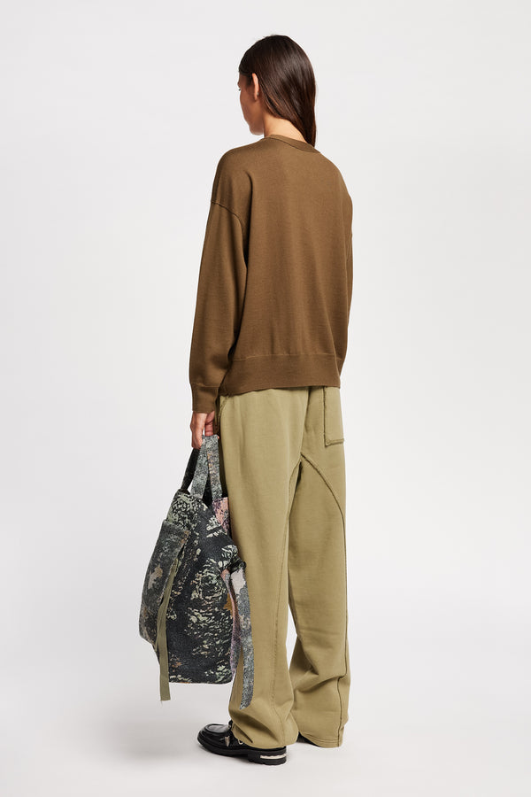Back angle view on Model of the Descend Loose Fit Merino Knit in brown, a relaxed-fit merino wool sweater with a crew neck. 