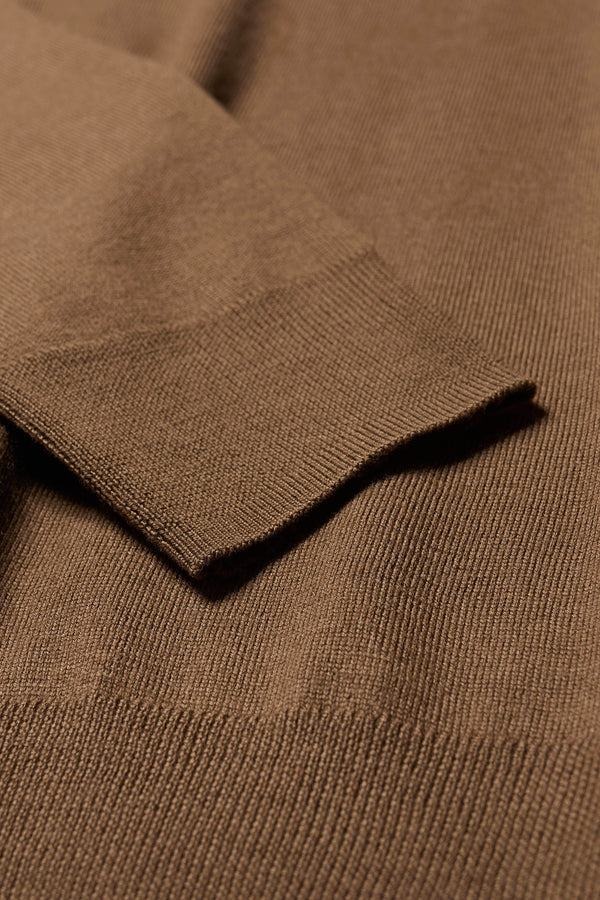 Close up fabric details of the Descend Loose Fit Merino Knit in brown, a relaxed-fit merino wool sweater with a crew neck. 