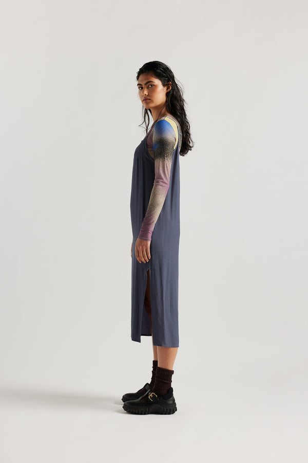 Side of female model indigo blue Mid-length slip dress with straight neckline and relaxed silhouette