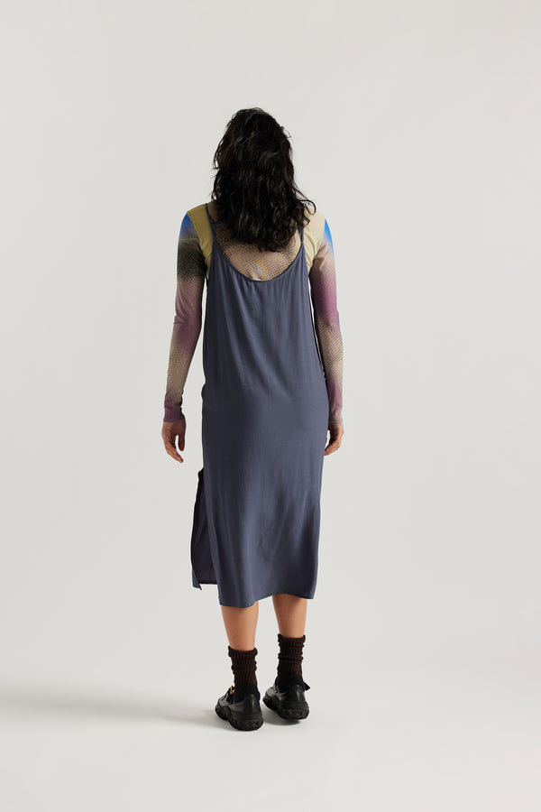 Back of female model indigo blue Mid-length slip dress with straight neckline and relaxed silhouette